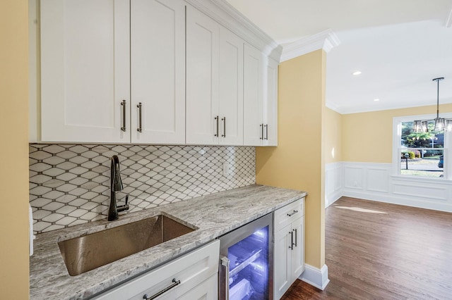 kitchen with white cabinets, decorative backsplash, sink, and beverage cooler