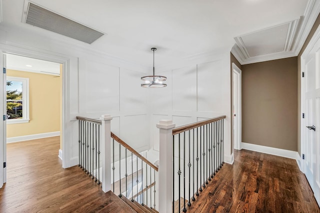 corridor featuring a notable chandelier, dark hardwood / wood-style floors, and ornamental molding