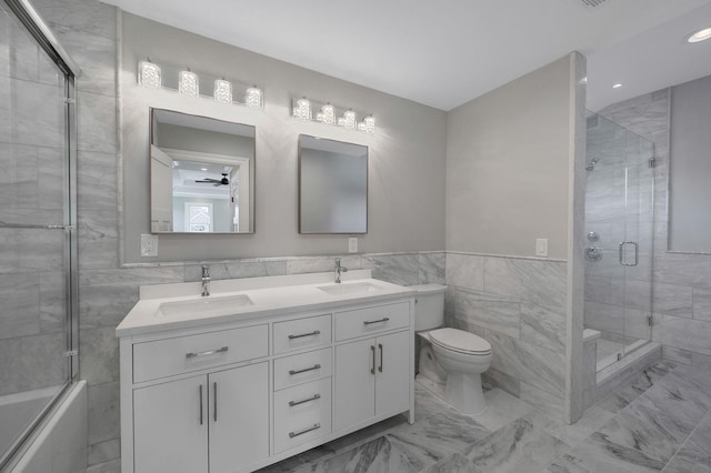 full bathroom with vanity, enclosed tub / shower combo, tile walls, and toilet