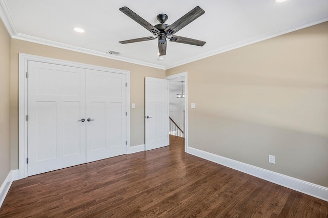 unfurnished bedroom with a closet, ceiling fan, dark hardwood / wood-style flooring, and crown molding