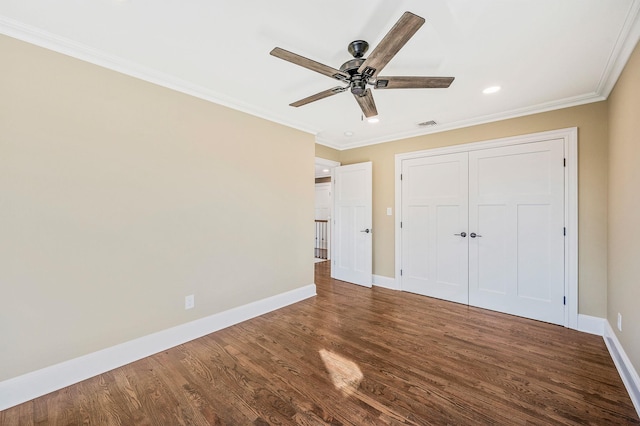 unfurnished bedroom with ceiling fan, crown molding, dark wood-type flooring, and a closet