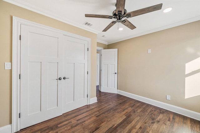 unfurnished bedroom featuring ceiling fan, dark hardwood / wood-style floors, crown molding, and a closet