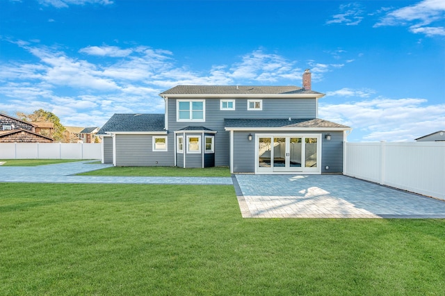 rear view of property with a yard and a patio