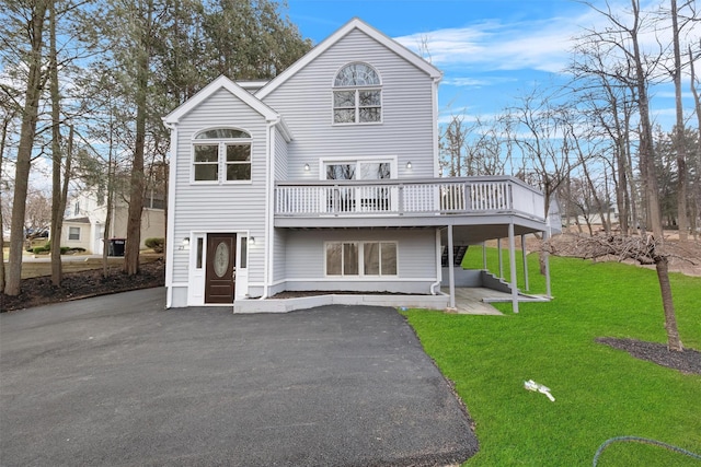 view of front facade with a deck and a front lawn