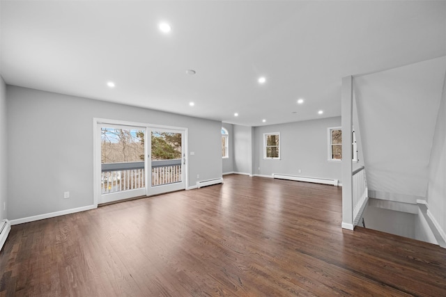 unfurnished living room featuring baseboard heating and dark hardwood / wood-style floors