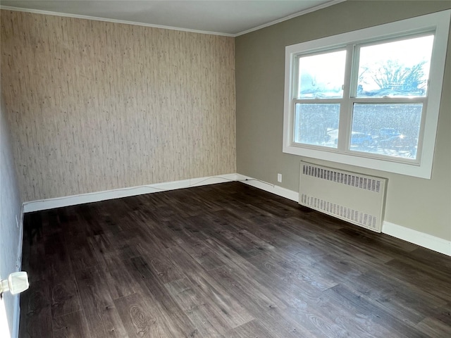 spare room with hardwood / wood-style flooring, radiator, and ornamental molding