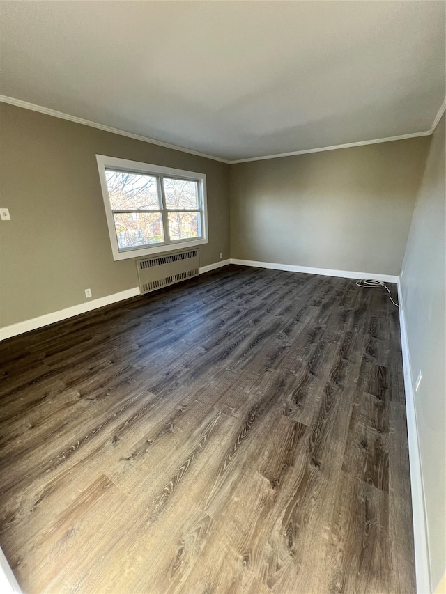 empty room featuring radiator, crown molding, and dark wood-type flooring