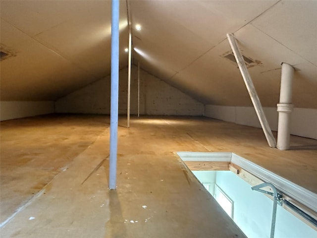 bonus room featuring lofted ceiling and concrete floors