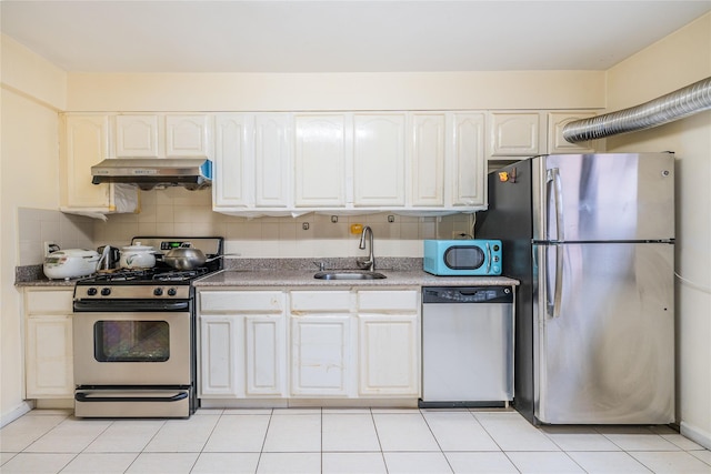 kitchen featuring sink, backsplash, stainless steel appliances, white cabinets, and stone countertops