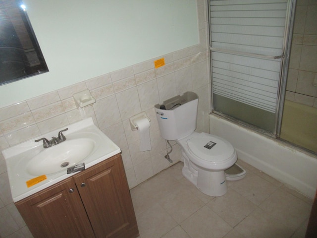 9 Jim Ln, Putnam Valley, NY 10579 - bathroom with vanity, shower / bath combination with glass door, tile walls, tile patterned floors, and a wainscoted wall