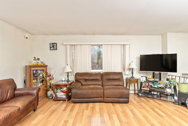 living room featuring light hardwood / wood-style floors and a baseboard heating unit