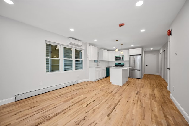 kitchen with pendant lighting, a center island, white cabinets, baseboard heating, and stainless steel appliances