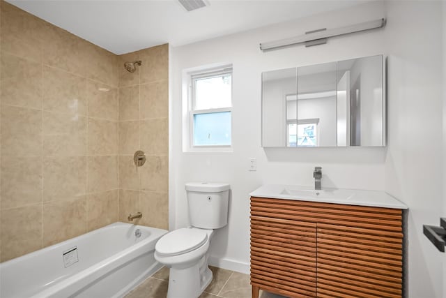 full bathroom featuring tile patterned floors, vanity, tiled shower / bath combo, and toilet