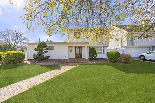 view of property featuring a garage and a front lawn