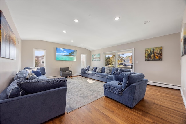 living room with hardwood / wood-style floors, a baseboard heating unit, and vaulted ceiling