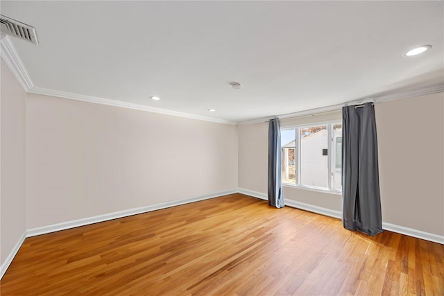 empty room featuring ornamental molding and light hardwood / wood-style flooring