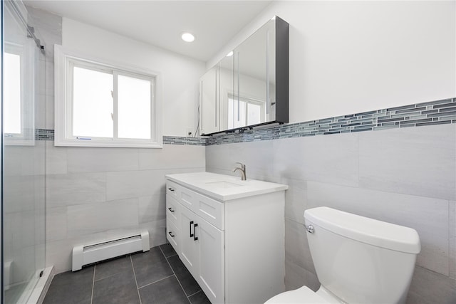 bathroom with vanity, toilet, baseboard heating, and tile walls