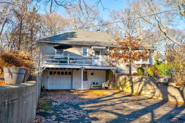 back of property with a garage and a deck