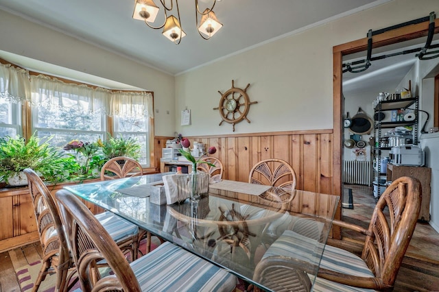 dining space with a notable chandelier, wood-type flooring, and ornamental molding