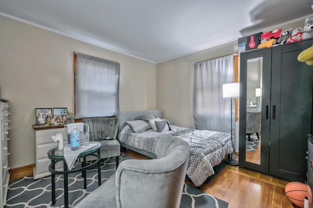 bedroom with crown molding and hardwood / wood-style floors