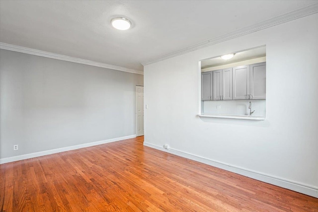 spare room with crown molding and light hardwood / wood-style flooring