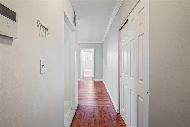 corridor with dark wood-type flooring and ornamental molding