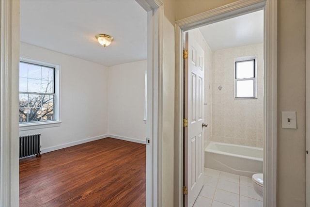 bathroom with radiator, toilet, a wealth of natural light, and wood-type flooring