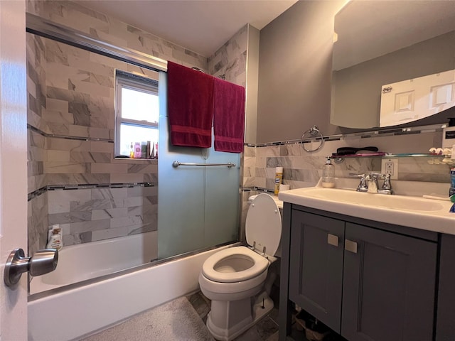 full bathroom featuring backsplash, bath / shower combo with glass door, toilet, vanity, and tile walls