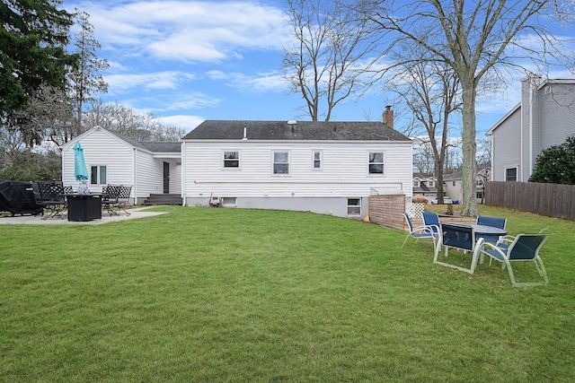 back of house featuring a patio, a yard, and a fire pit