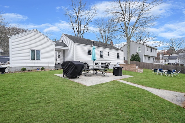 back of property with a lawn and a patio area