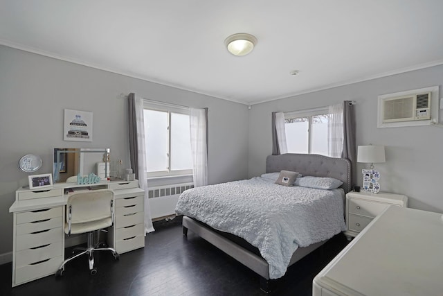 bedroom with radiator, dark hardwood / wood-style flooring, multiple windows, and crown molding