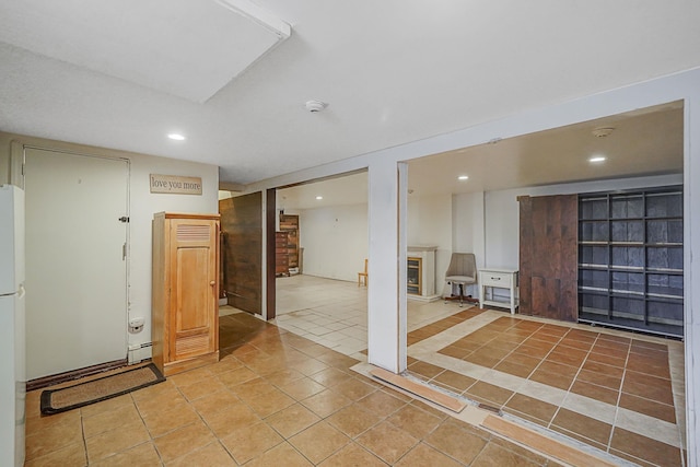 interior space with light tile patterned floors and white fridge