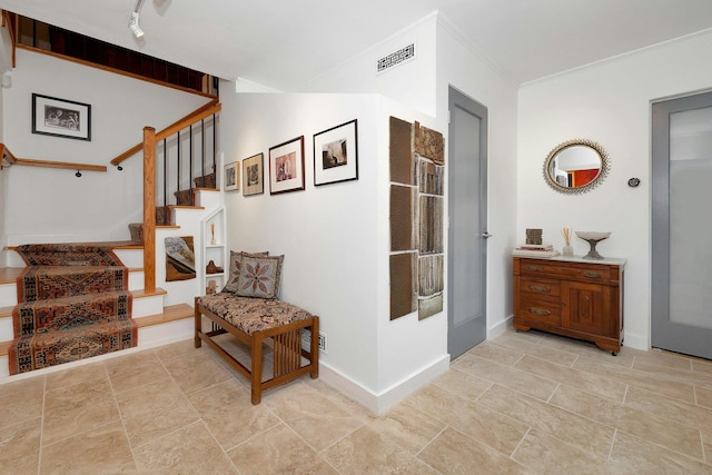 interior space with crown molding and track lighting