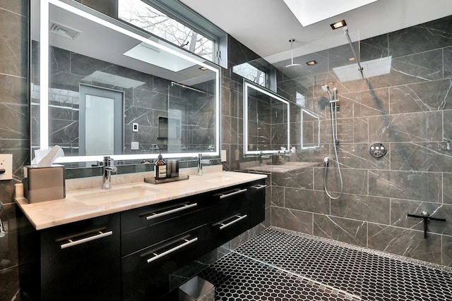 bathroom featuring vanity, tile walls, and a tile shower