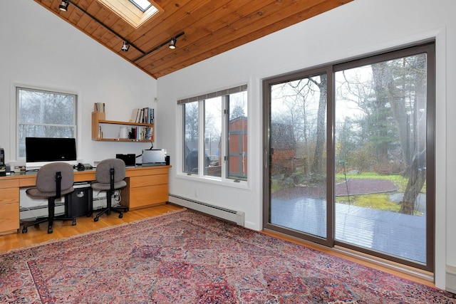 home office featuring lofted ceiling with skylight, baseboard heating, track lighting, wooden ceiling, and light wood-type flooring