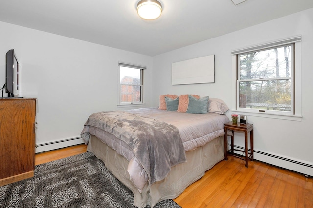 bedroom with a baseboard radiator and wood-type flooring