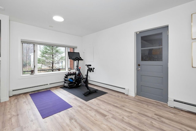 exercise room with light hardwood / wood-style flooring and a baseboard radiator