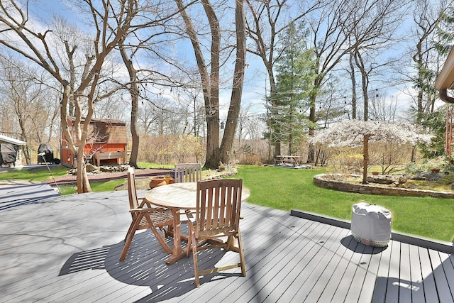 wooden terrace featuring a yard and a patio area