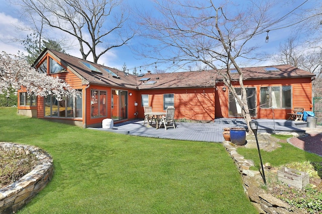 rear view of property featuring a sunroom, a yard, and a patio area