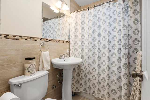 bathroom with tile walls and toilet