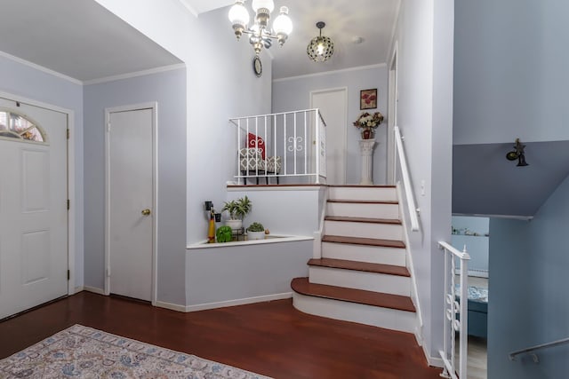 foyer entrance featuring a notable chandelier, ornamental molding, and dark wood-type flooring