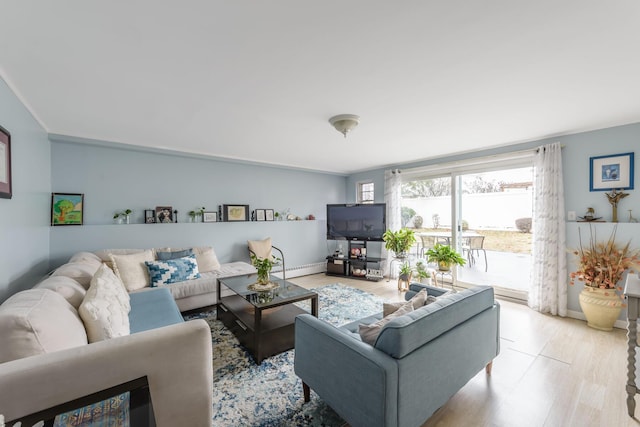 living room with light wood-type flooring, baseboard heating, and ornamental molding