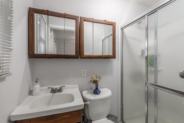 bathroom featuring vanity, toilet, and an enclosed shower