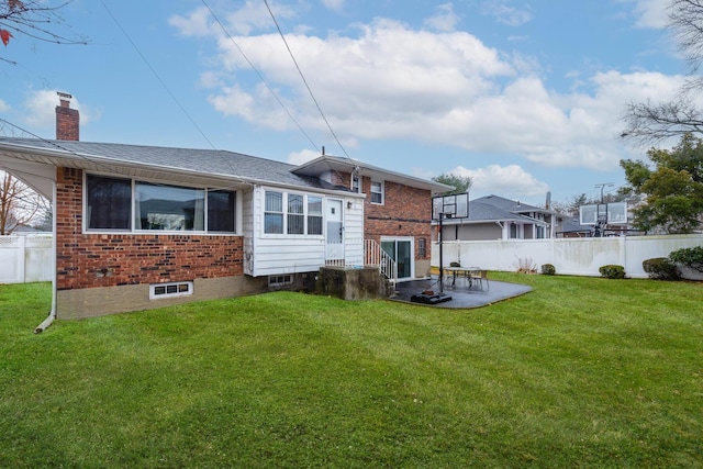 back of property with a yard and a patio area