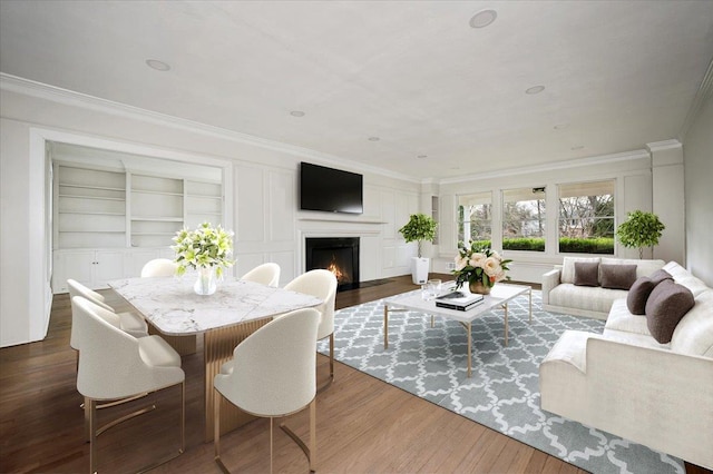 living room with built in features, ornamental molding, and dark wood-type flooring