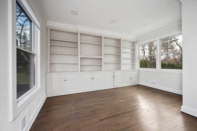 interior space with crown molding, built in features, dark wood-type flooring, and a wealth of natural light