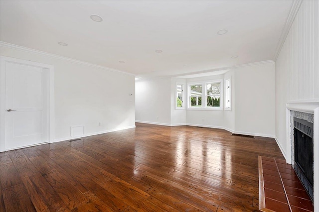 unfurnished living room with ornamental molding, dark wood-type flooring, and a tiled fireplace