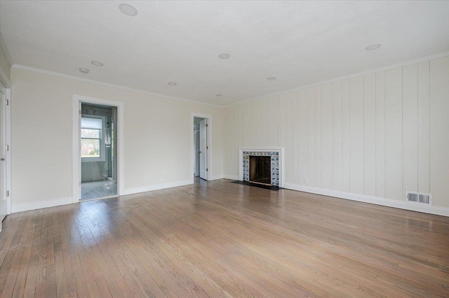 unfurnished living room with crown molding and light hardwood / wood-style floors