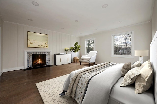 bedroom with a fireplace, crown molding, and dark hardwood / wood-style flooring