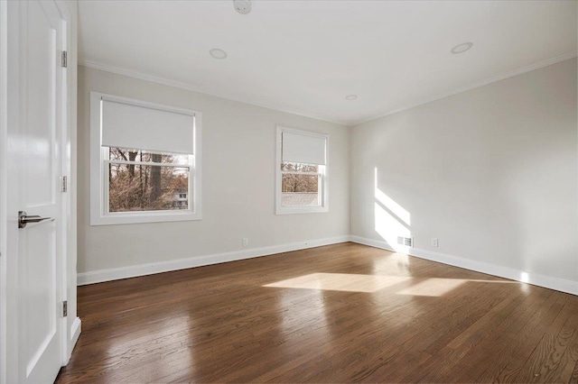 spare room with crown molding, a healthy amount of sunlight, and dark hardwood / wood-style floors